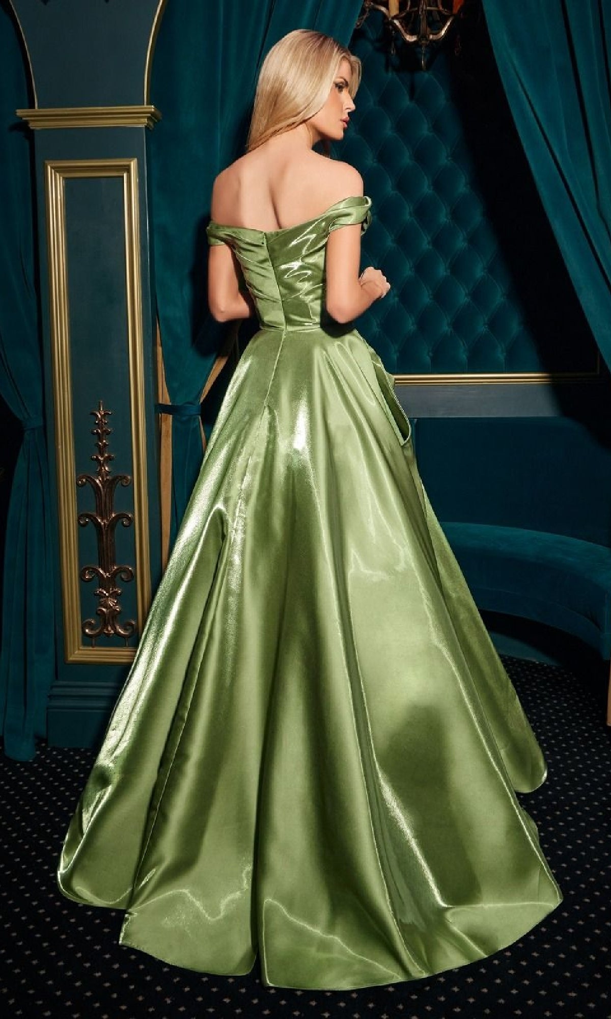 A woman with long blonde hair wears the Ladivine J885 long prom dress, standing with her back to the camera in an elegant blue and gold room.